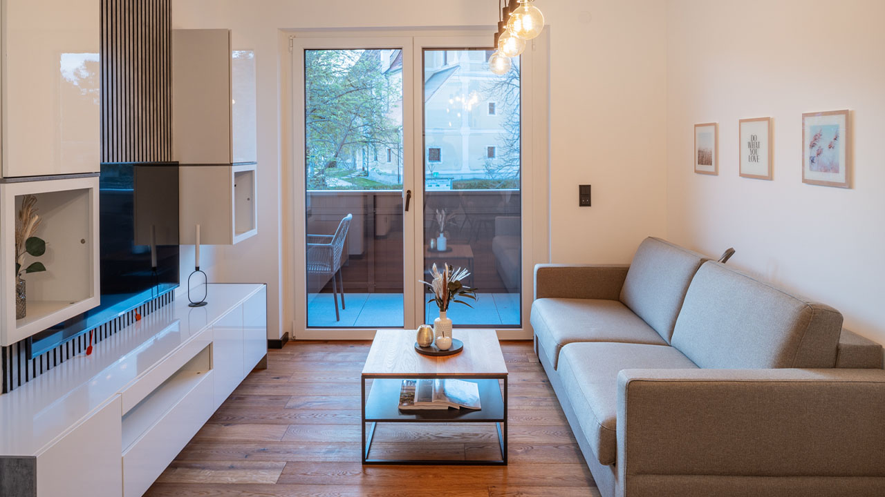 mi-vida-apartment-bliss-rivervista-wohnbereich-couch-tv-balkon